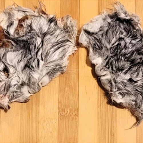 Two pieces of fur on a wooden surface